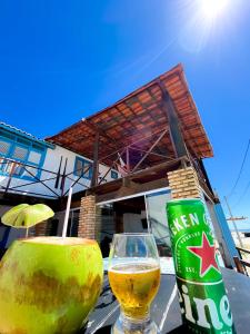 a bottle of beer and a glass on a table at Pousada e restaurante casa dos ventos in Icapuí