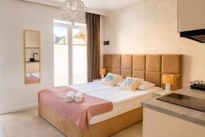 a bedroom with a bed with two slippers on it at Apartamenty Sunny Stay Jastarnia in Jastarnia