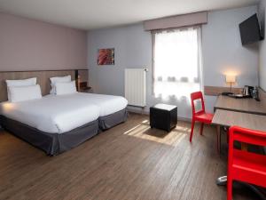 a hotel room with a bed and a table and a desk at Adagio Access Lyon Centre Université in Lyon