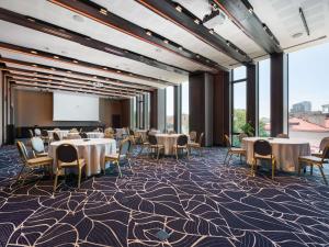 a conference room with tables and chairs and a projection screen at Movenpick Hotel Tallinn in Tallinn