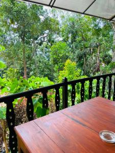 a wooden table on a balcony with a view of a forest at Ella Shali's home in Ella