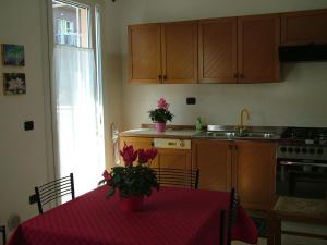 una cucina con un tavolo con un vaso di fiori sopra di San Teodoro Apartment a Mestre