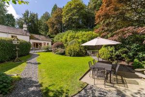 a garden with a table and an umbrella at 4 Bed in Hawkshead oc-lr116 in Hawkshead