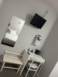 a room with a desk and a mirror and a bed at Au Bon Accueil in Alban