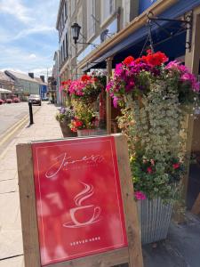 a sign in front of a store with flowers at The Kings Head Inn in Llandovery