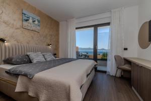 a bedroom with a bed with a view of the ocean at Villa Josip in Sukošan +117 photos