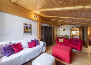 a living room with a white couch and red chairs at Zimmer in Celerina in Celerina
