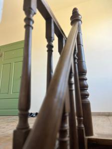 a wooden stair railing with a green door in the background at Gästehof Tultewitz in Naumburg
