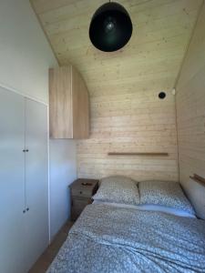 a bedroom with a bed and a black light at Domek nad plażą in Chańcza