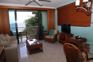 a living room with a television and a balcony at Point Pleasant Resort® 1BR Suite with Ocean Views in Nazareth