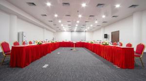 a large room with red tables and chairs with flowers on them at Lancaster Accra in Accra +67 photos