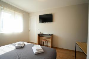 a bedroom with a bed and a television on the wall at Studio M Les Suites Du Roubion in Montélimar