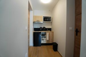 a small kitchen with a black refrigerator and microwave at Studio M Les Suites Du Roubion in Montélimar +1 photo