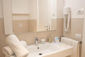 a bathroom with a white sink and a mirror at TH Ostuni - Ostuni Village in Ostuni