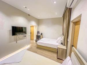 a bedroom with a bed and a flat screen tv at Sidi Hamad Pyramids View in Cairo