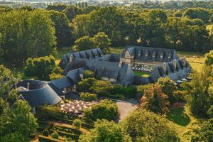 an aerial view of a mansion with trees at Les Manoirs de Tourgéville in Deauville