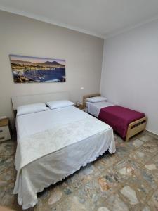 a bedroom with two beds and a painting on the wall at Casa vacanze Carmen House in Ercolano
