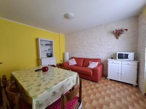 ein Wohnzimmer mit einem roten Sofa und einem Tisch in der Unterkunft Tra le Vette in Caspoggio