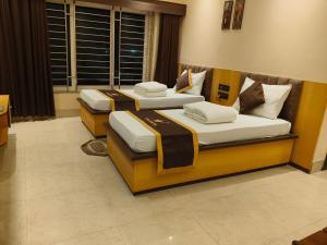 two beds in a hotel room withskirts at NAKSHATRA Hotel, Restaurant & Banquet in Barddhamān