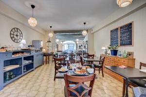 a dining room with tables and chairs and a cafeteria at Logis Hôtel La Bastide d'Entraigues in Entraigues-sur-la-Sorgue