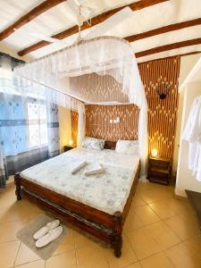 a bedroom with a large bed in a room at Simba Apartments in Diani Beach +70 photos