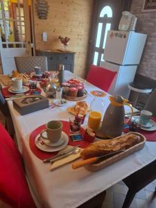 a table with breakfast foods and coffee on it at Le Bois Rouland in Le Mesnil-Mauger +13 photos