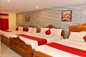 a bedroom with two beds with red and white pillows at Hotel Hill Edge in Kodaikānāl