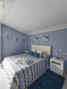 a bedroom with a large bed with blue walls at Tejas verdes in Argoños