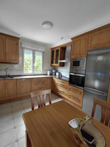 a kitchen with wooden cabinets and a wooden table at Tejas verdes in Argoños