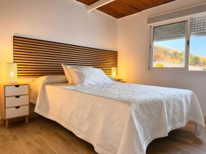 a bedroom with a white bed and a window at Finca Domingo in Fasnia