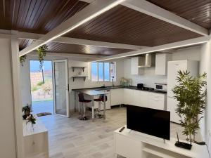 a kitchen with white cabinets and a flat screen tv at Finca Domingo in Fasnia