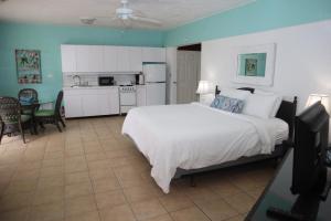 a bedroom with a large white bed and a kitchen at Point Pleasant Resort® 1BR Suite with Ocean Views in Nazareth