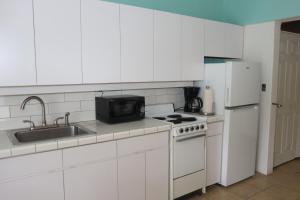 a white kitchen with a sink and a stove and refrigerator at Point Pleasant Resort® 1BR Suite with Ocean Views in Nazareth +1 photo