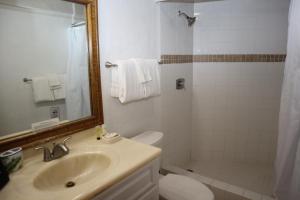 a bathroom with a sink and a toilet and a mirror at Point Pleasant Resort® 1BR Suite with Ocean Views in Nazareth