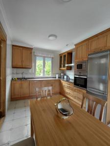 a kitchen with wooden cabinets and a wooden table at Tejas verdes in Argoños +12 photos
