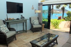a living room with chairs and a table and a tv at Point Pleasant Resort® 1BR Suite with Ocean Views in Nazareth