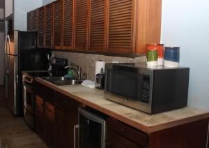 a kitchen counter with a microwave and a sink at Point Pleasant Resort® 1BR Suite with Ocean Views in Nazareth +4 photos