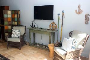 a living room with two chairs and a table with a television at Point Pleasant Resort® 1BR Suite with Ocean Views in Nazareth