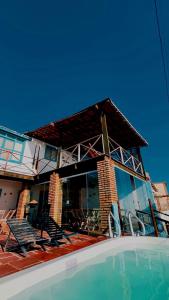 a house with a swimming pool in front of it at Pousada e restaurante casa dos ventos in Icapuí