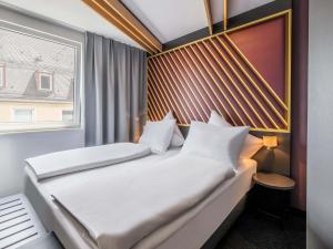 a bedroom with two beds and a window at B&B Hotel Nürnberg-City in Nuremberg