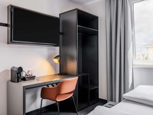 a hotel room with a desk and a chair at B&B Hotel Nürnberg-City in Nuremberg