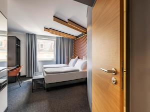 a hotel room with a bed and a desk at B&B Hotel Nürnberg-City in Nuremberg +22 photos