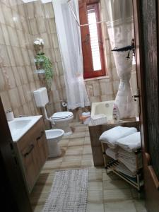 a bathroom with a toilet and a sink and a tub at Casa Monteserrato in Terrasini +29 photos