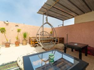 a patio with a glass table and a swing at TAMOUNT Surf House in Agadir
