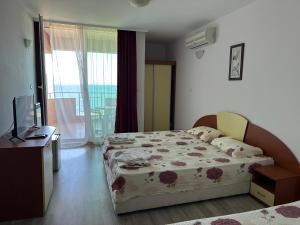a bedroom with a bed and a desk and a television at стаи за гости Гергана in Tsarevo