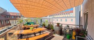 an outdoor patio with tables and benches on a balcony at Babelfish Hostel in Würzburg