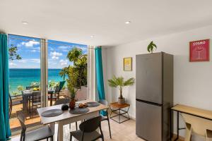 a kitchen and dining room with a table and a refrigerator at Watalibi - Beachfront apartment Grand-Case in Grand Case