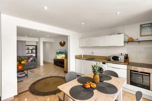 a kitchen and living room with a table and chairs at Watalibi - Beachfront apartment Grand-Case in Grand Case