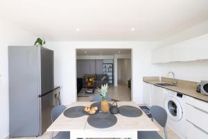 a kitchen and dining room with a table with a pineapple on it at Watalibi - Beachfront apartment Grand-Case in Grand Case +21 photos