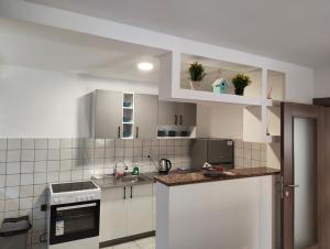 a kitchen with white cabinets and a counter top at Kravica Oasis in Ljubuški +25 photos